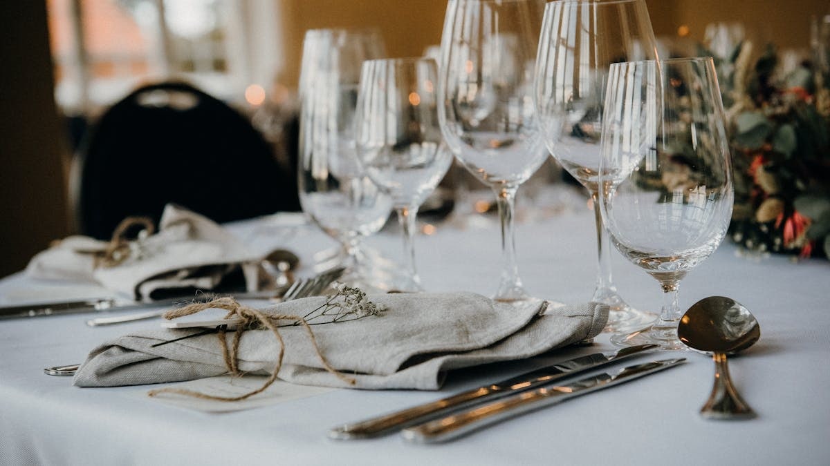 A classy table setup with fine cutlery, napkins, and elegant wine glasses ideal for formal dining.